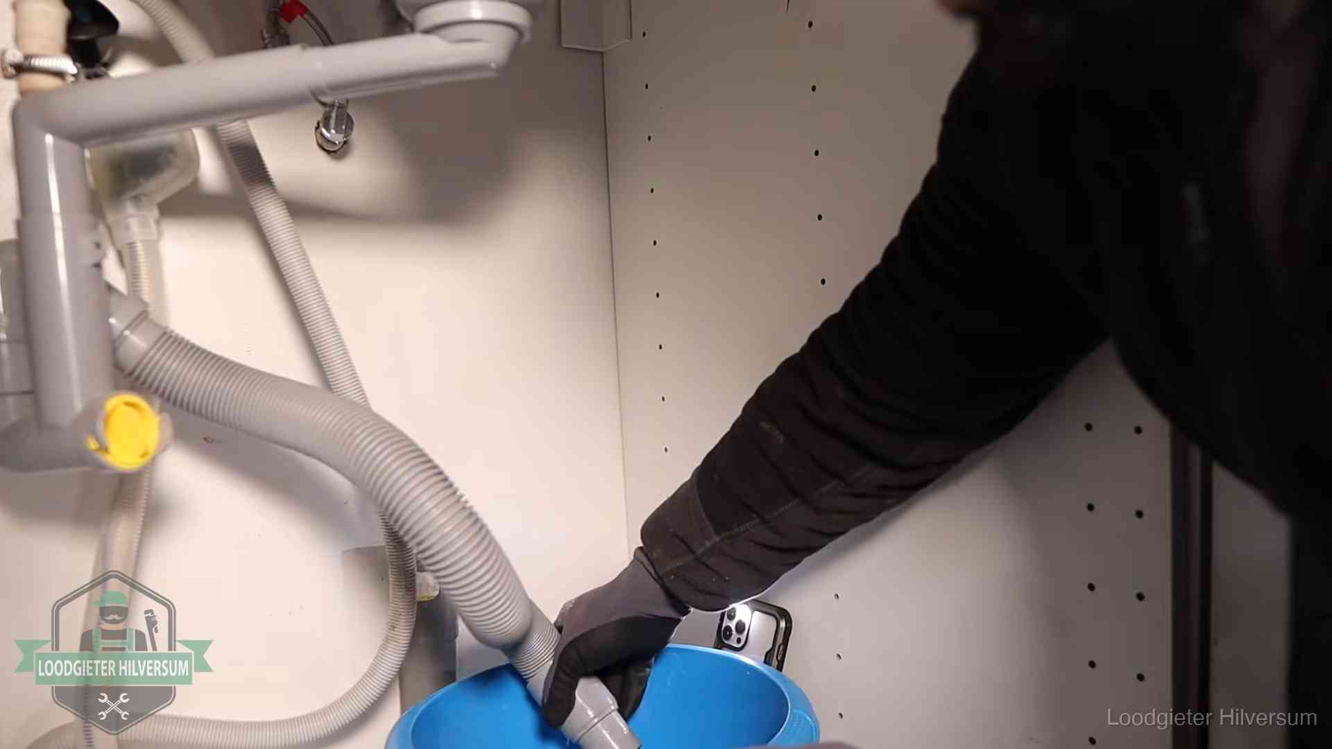 Afvoerslang loopt leeg in een emmer onder de gootsteen in Hilversum, een klus die je zelf kunt doen