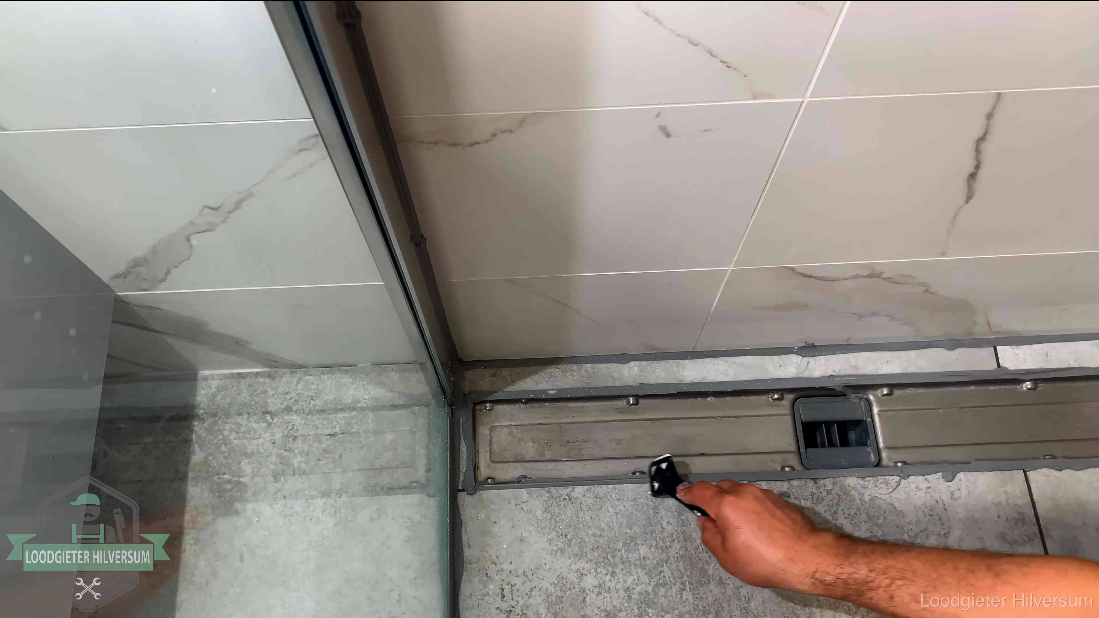 Lekkage in de badkamer verhelpen in Hilversum Verse kitrand langs de douchegoot in een betegelde badkamer in Hilversum