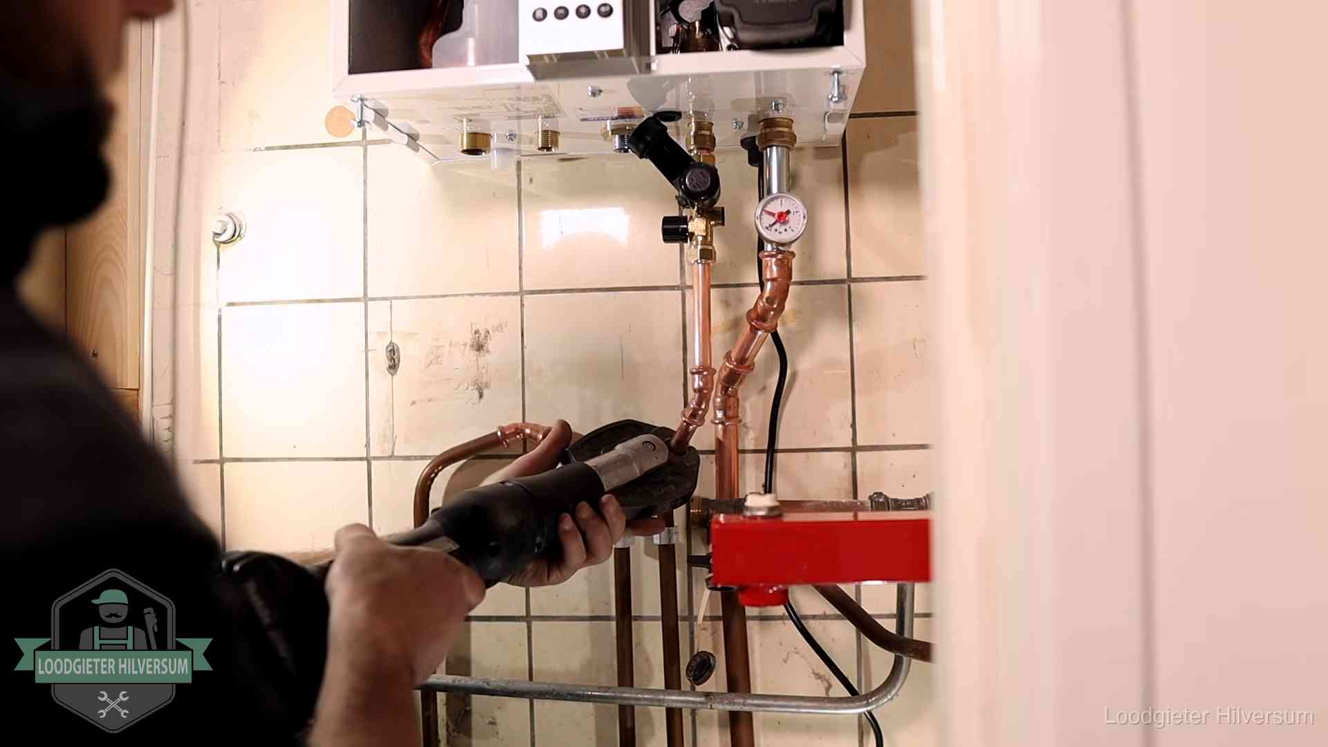 Cv-ketel onderhoud in Hilversum Monteur werkt aan de leidingen onder een cv-ketel in Hilversum