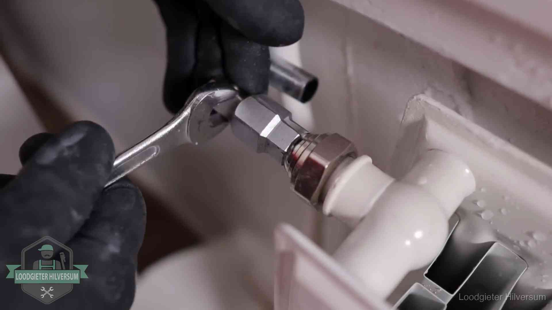 Radiatoren en waterzijdig inregelen in Hilversum Steeksleutel draait een wartelkoppeling op een radiatorkraan aan in Hilversum