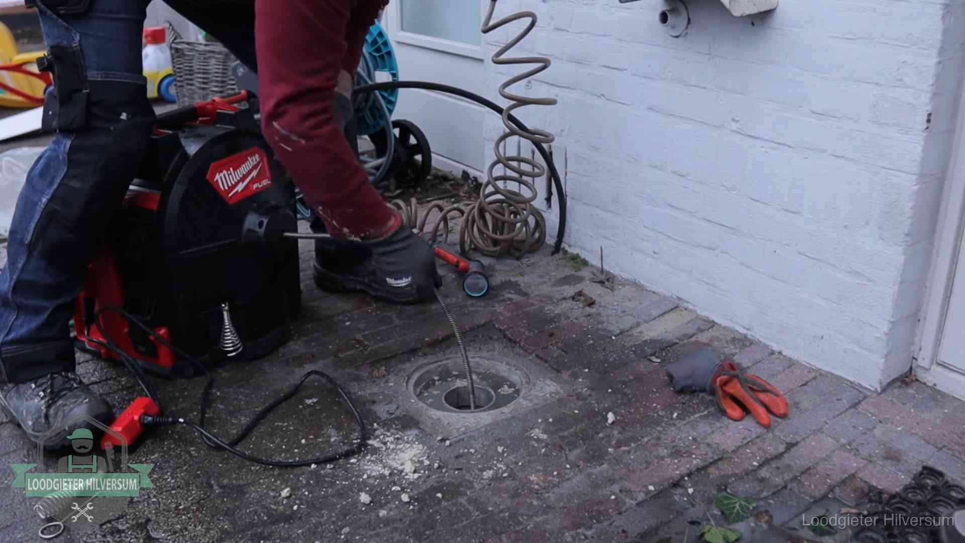 Spiraalmachine bij een ontstoppingsputje in de bestrating in Hilversum