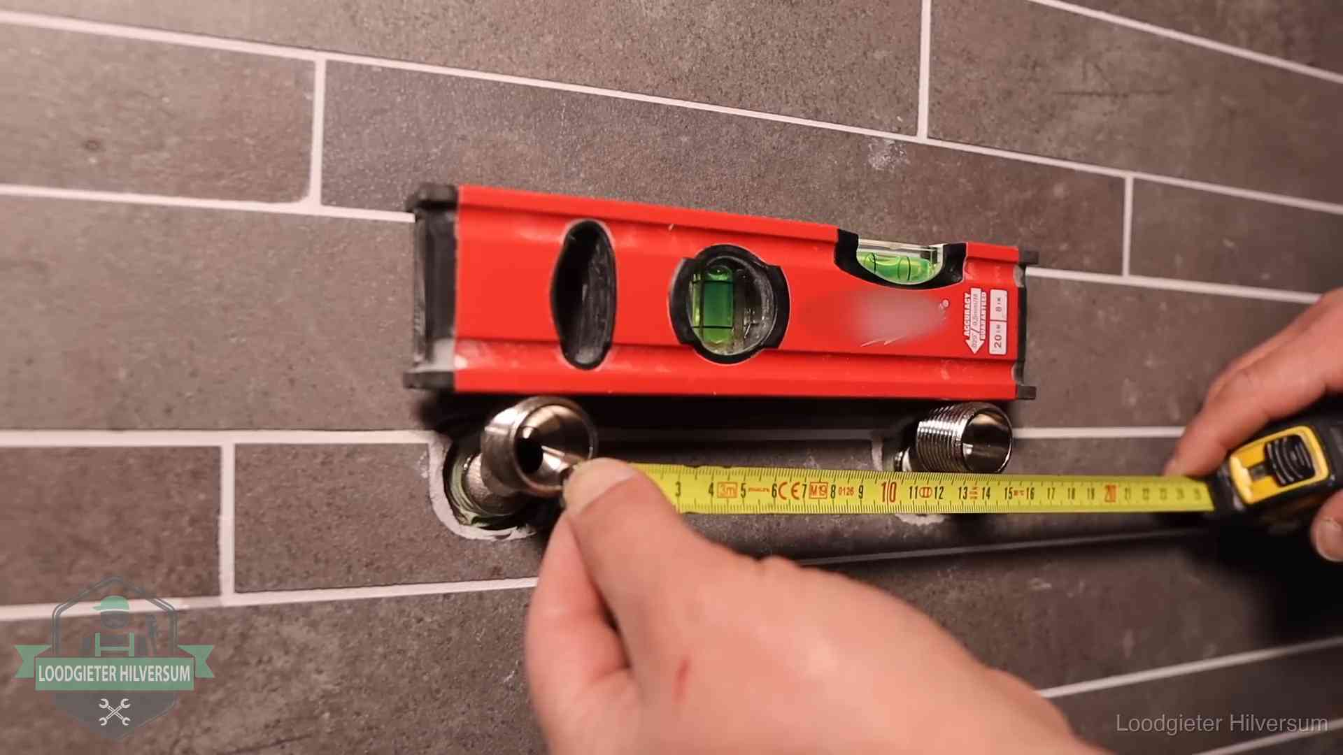 Waterpas en duimstok bij kraan-aansluitpunten in een badkamer in Hilversum