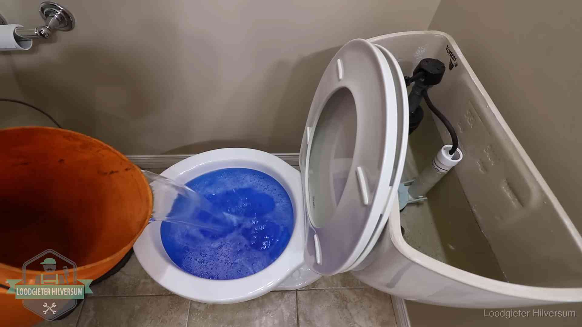 Water komt omhoog in de wc in Hilversum Water bij de wc-pot wordt met een emmer weggewerkt om schade te beperken in Hilversum